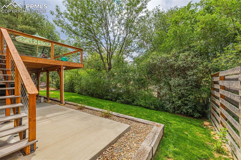 Image 41 of 44: View of grassy yard featuring stairway, a patio, and a deck