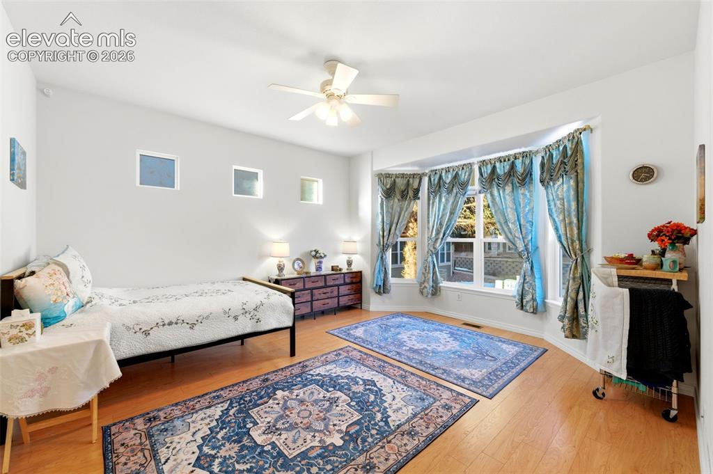 Image 11 of 31: Spacious room featuring wood-finish flooring, a multi-pane bay window, and 