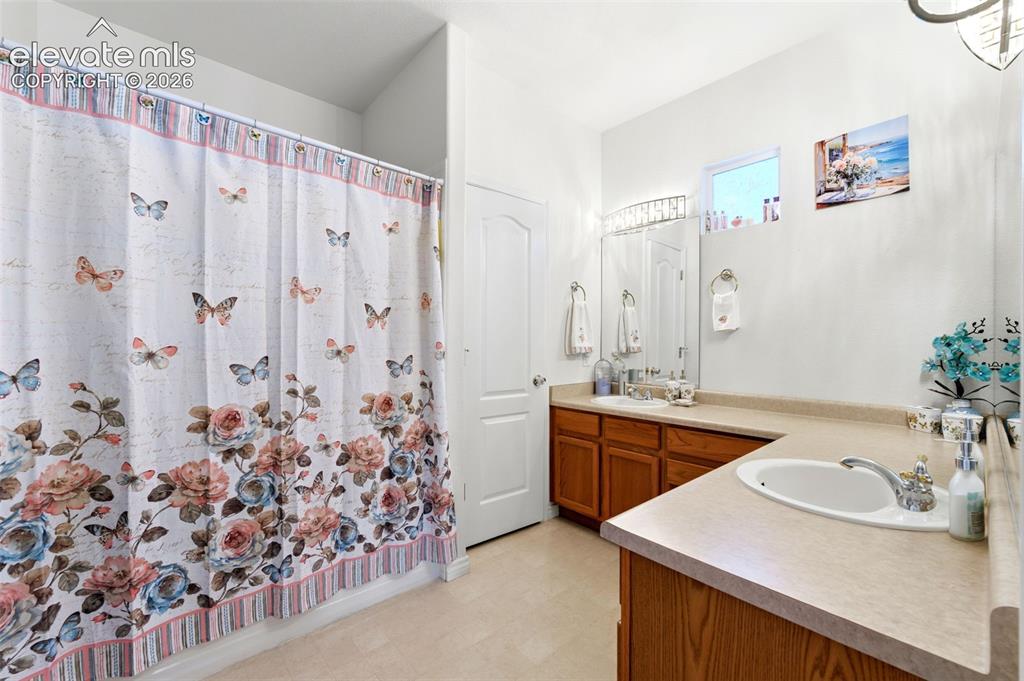 Image 14 of 31: Bathroom featuring a built-in vanity with wood cabinetry, a light-colored c