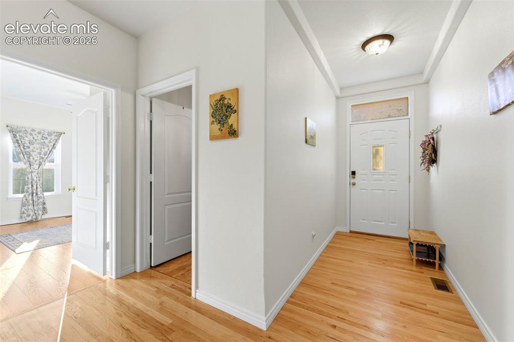 Image 15 of 31: Entryway featuring wood-finish flooring, a white paneled entry door with tr