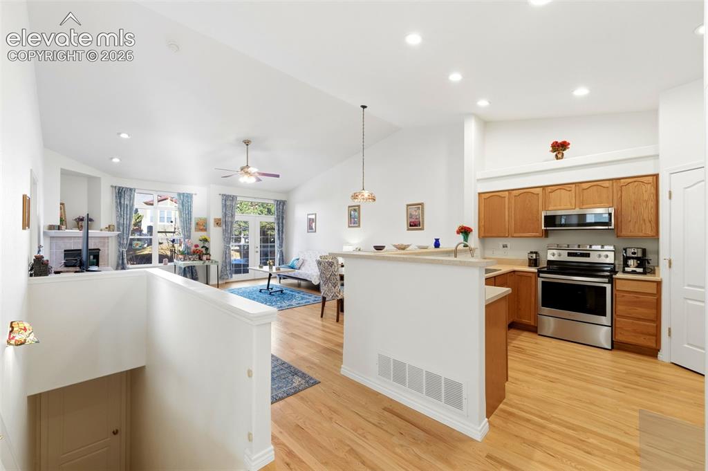 Image 18 of 31: Open-concept living area featuring a vaulted ceiling with recessed lighting