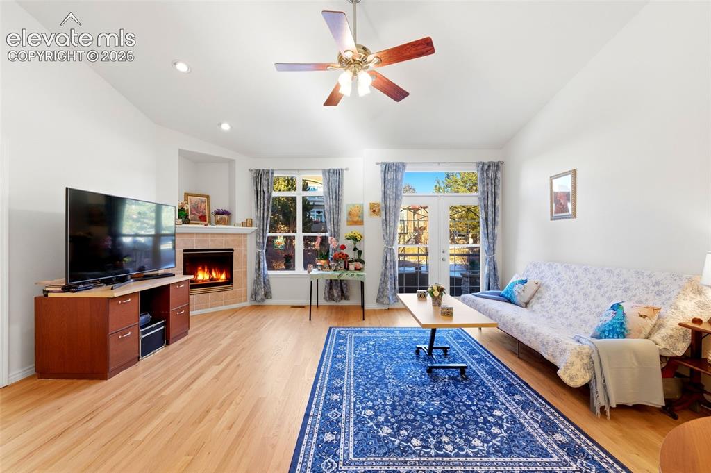 Image 2 of 31: Spacious living area featuring light wood-finish flooring and a corner fire