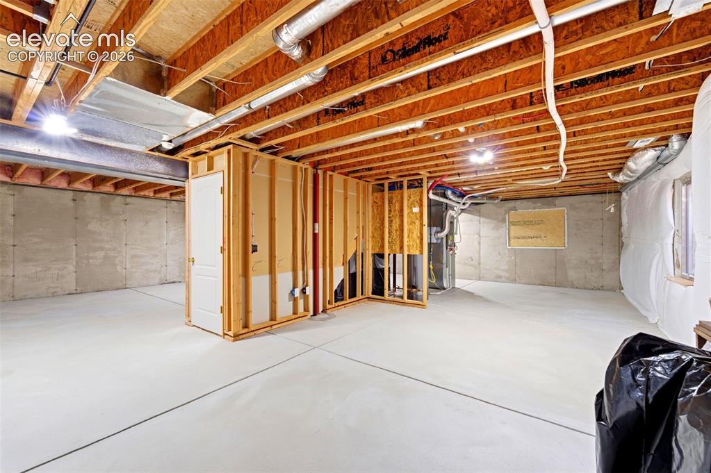 Image 21 of 31: Spacious unfinished basement offering concrete flooring, exposed ceiling jo