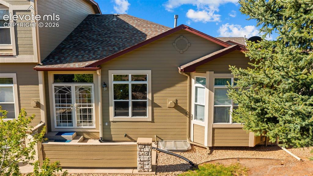 Image 24 of 31: Exterior siding in a warm earth tone, featuring a multi-pane glass door wit