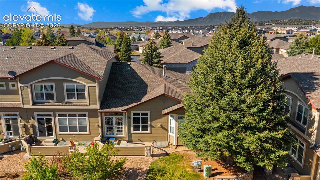 Image 26 of 31: Exterior featuring multiple windows, a rear patio with stone landscaping, a