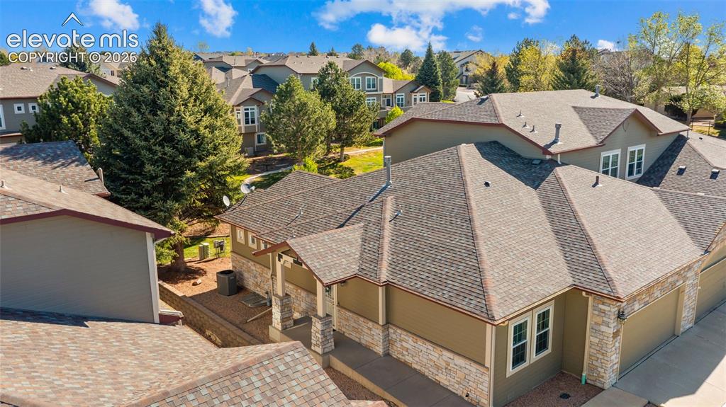 Image 27 of 31: Multi-level residential property with neutral siding, stone veneer accents,