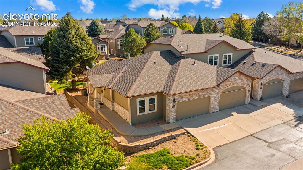 Image 28 of 31: Stone and stucco exterior with multiple attached garages, a covered front e