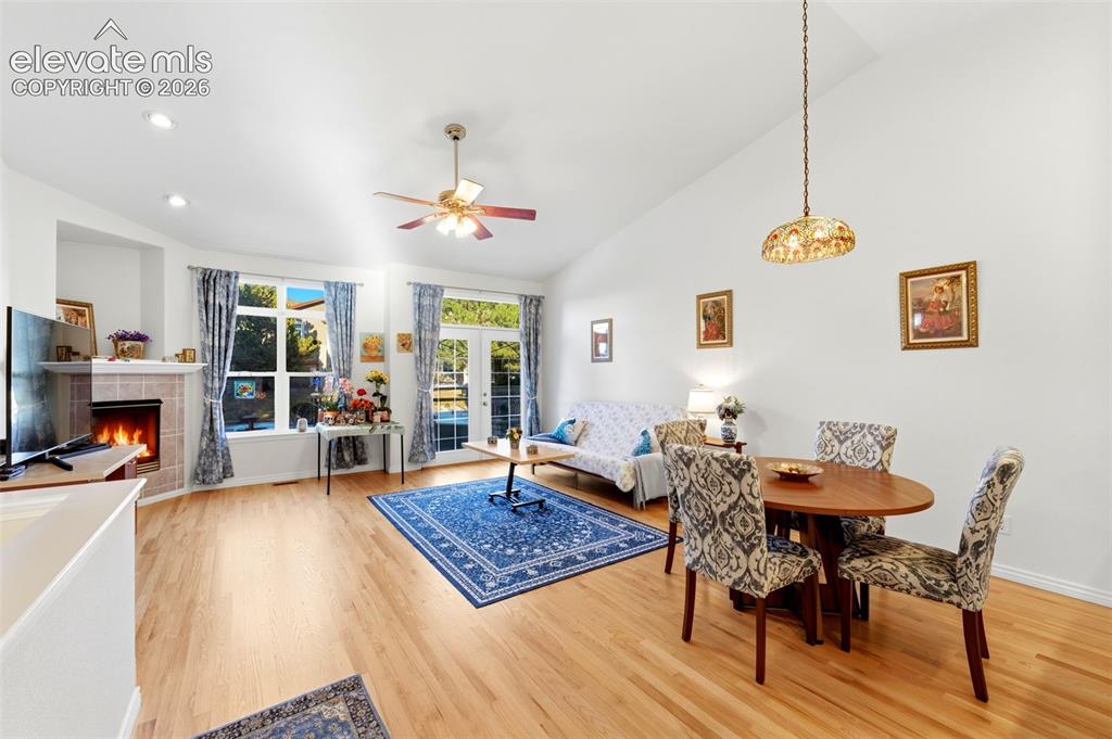 Image 4 of 31: Open-concept living space featuring wood-finish flooring, a tiled fireplace