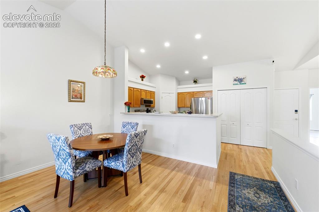 Image 6 of 31: Dining area featuring wood-finish flooring and a decorative hanging light f