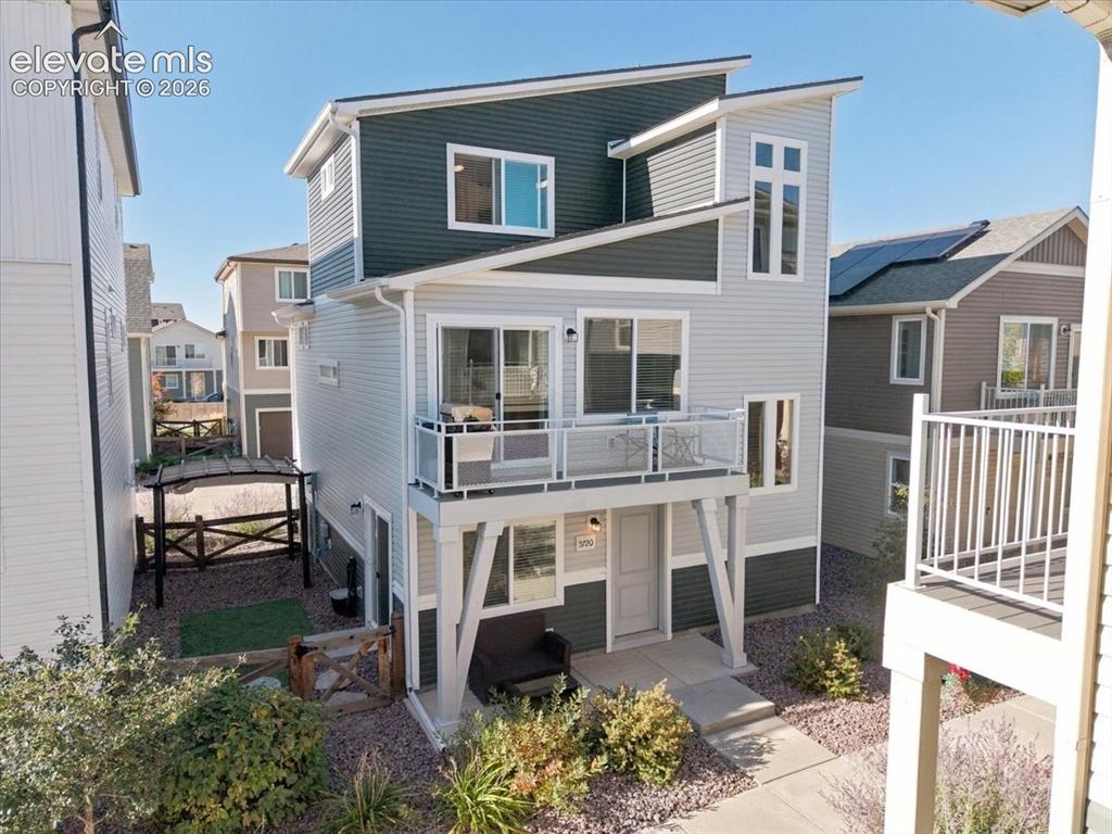 Caption: The modern exterior features a second-story balcony and a landscaped rock garden.