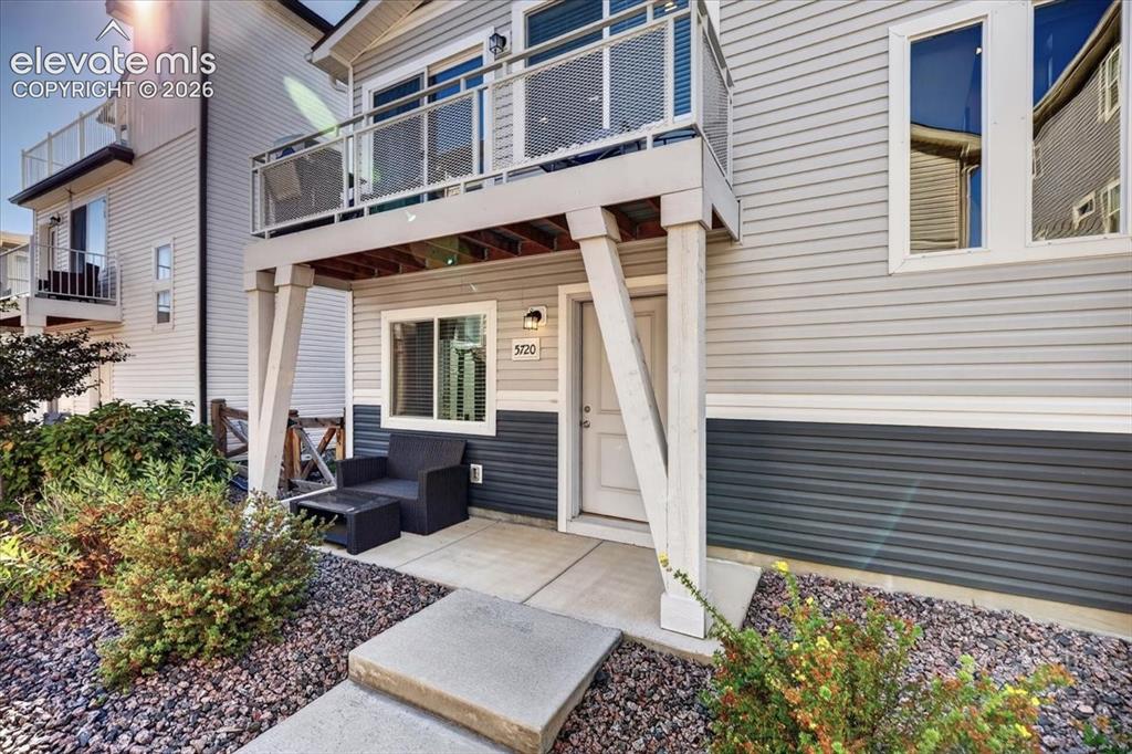 Image 2 of 48: The cheerful and inviting entry with a patio and sitting area.