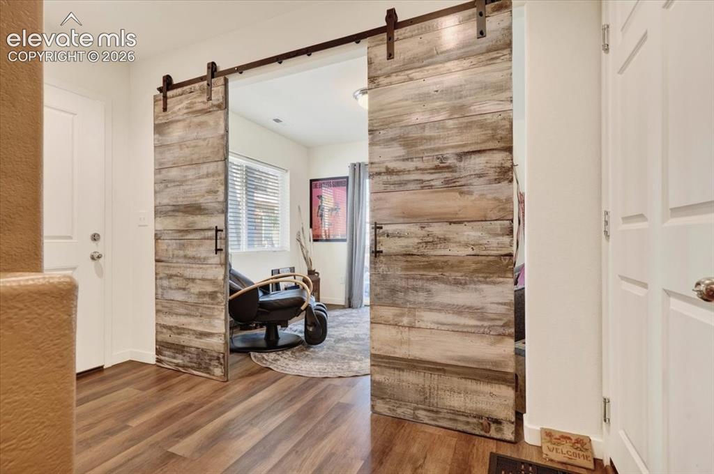 Image 3 of 48: The spacious foyer has luxury plank flooring and a farmhouse barn door lead