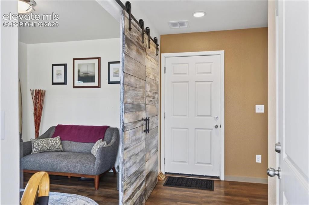 Image 8 of 48: The foyer is spacious and opens to the garage and staircase.