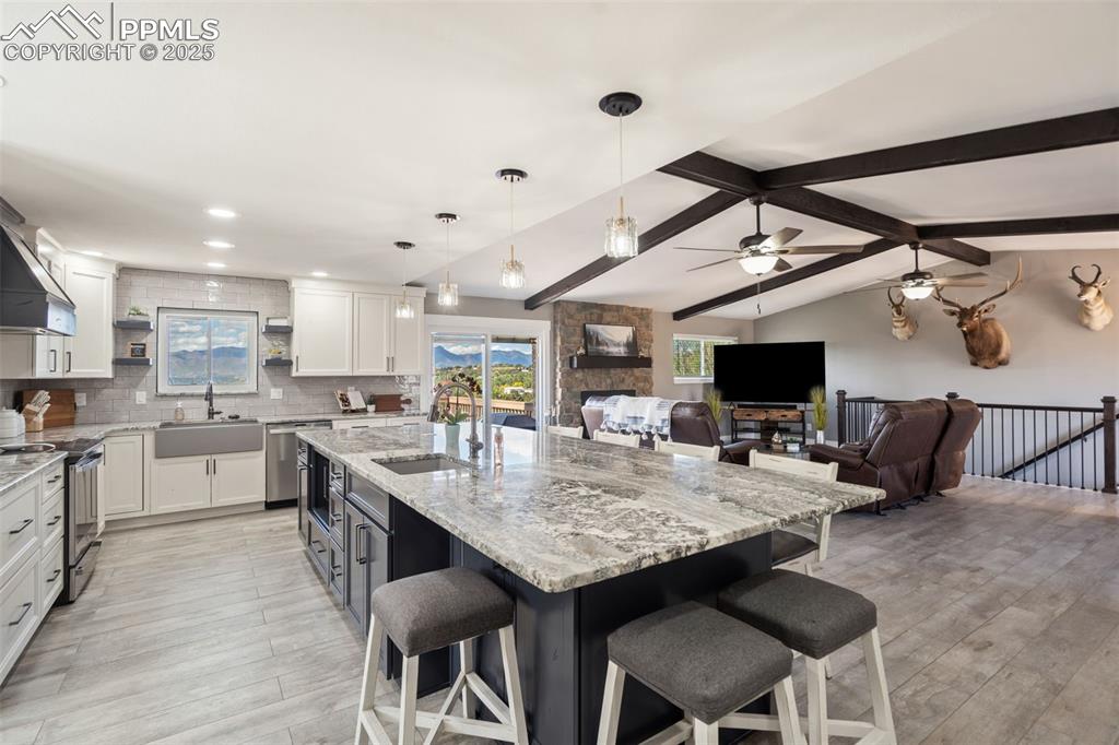 Image 13 of 49: This designer kitchen is stunning with a huge island and breakfast bar, bea