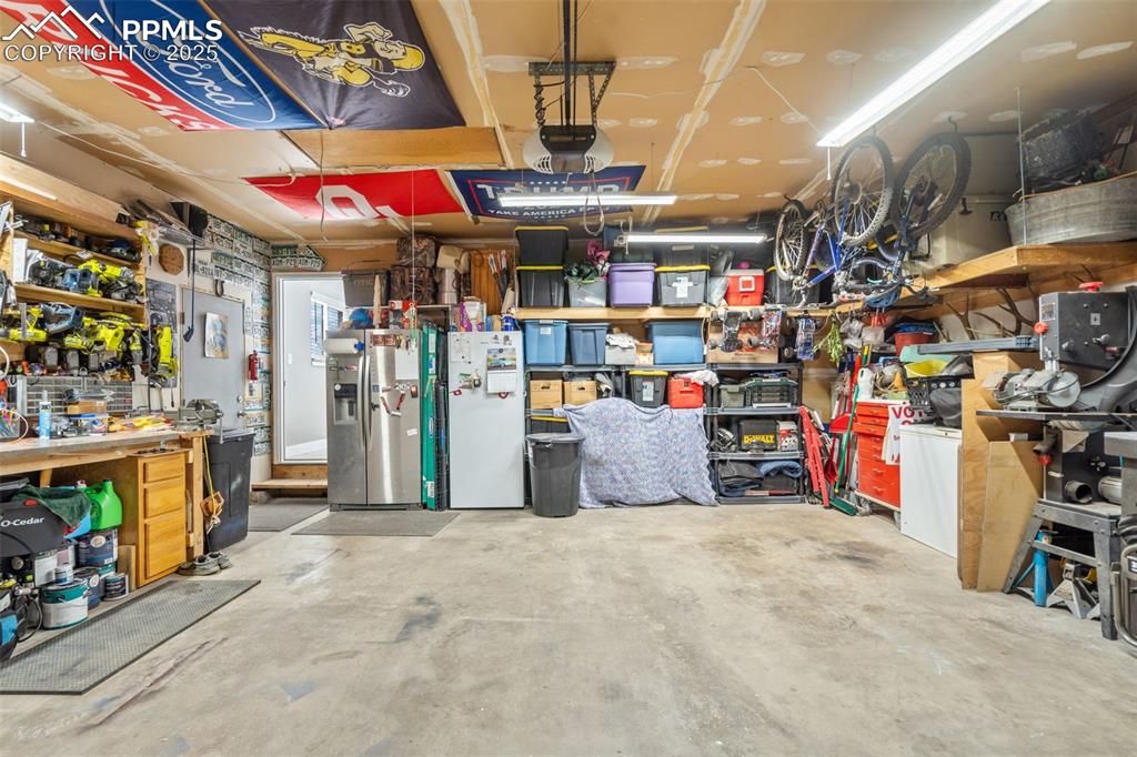 Image 36 of 49: 2-Car garage has good workbench area and shelving. 