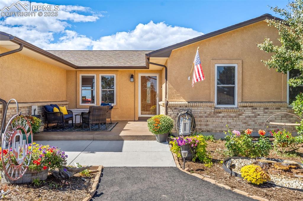 Image 7 of 49: A welcoming front entrance with low-maintenance xeriscape and a stamped con
