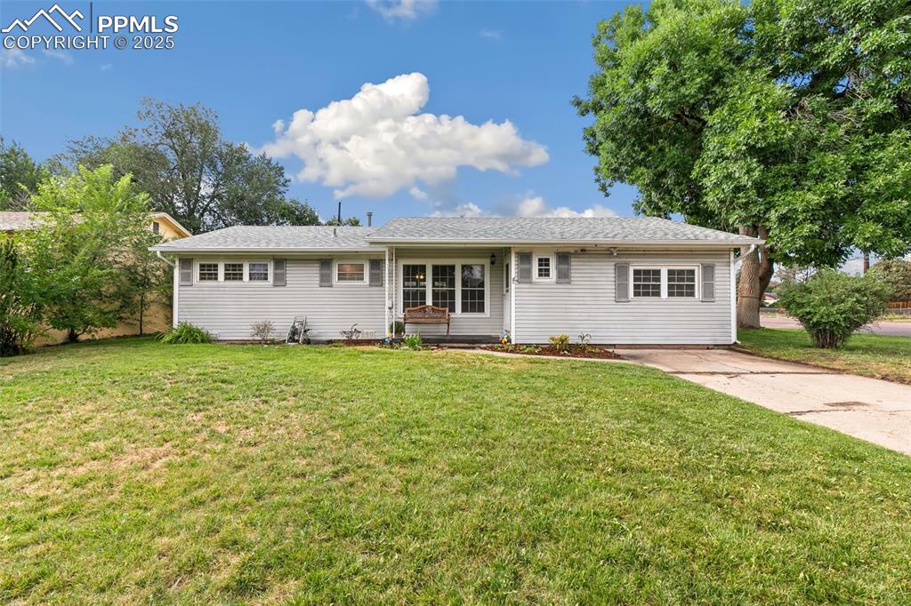 Caption: Ranch-style home with a front lawn, driveway, and a shingled roof