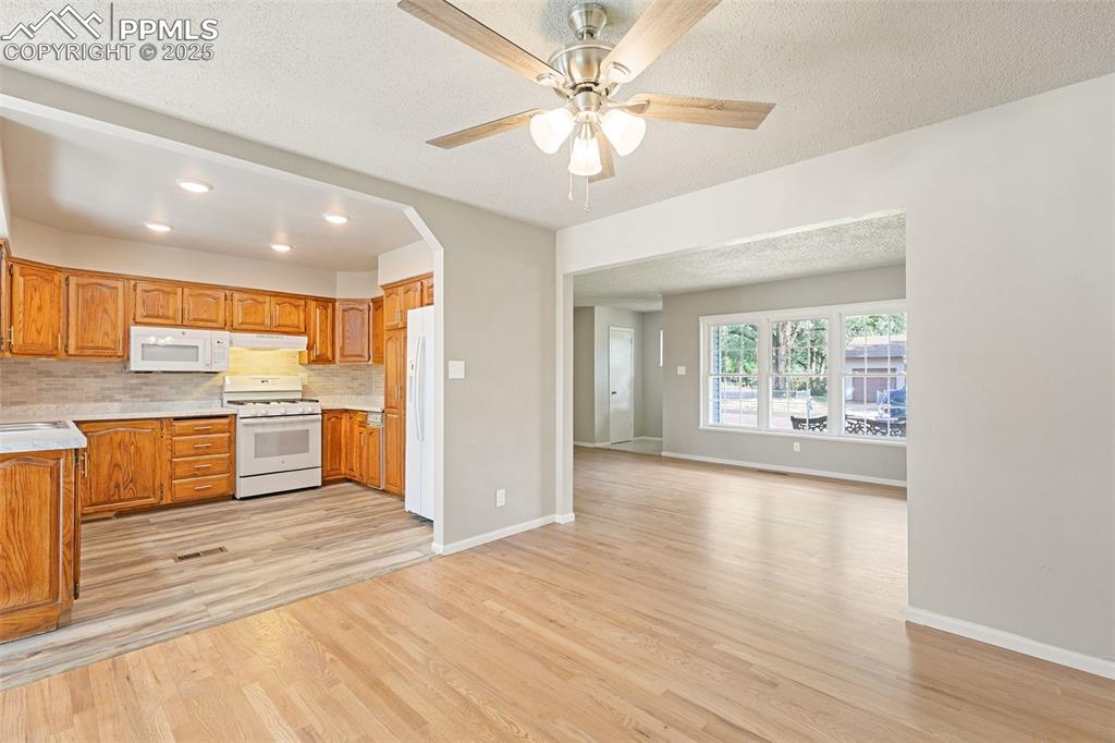 Image 7 of 17: Kitchen featuring tasteful backsplash, light countertops, a textured ceilin
