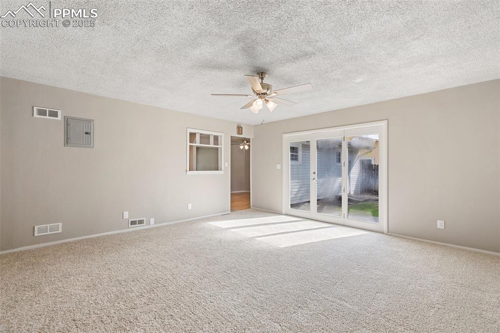 Image 9 of 17: Spare room with carpet flooring, a ceiling fan, a textured ceiling, and ele