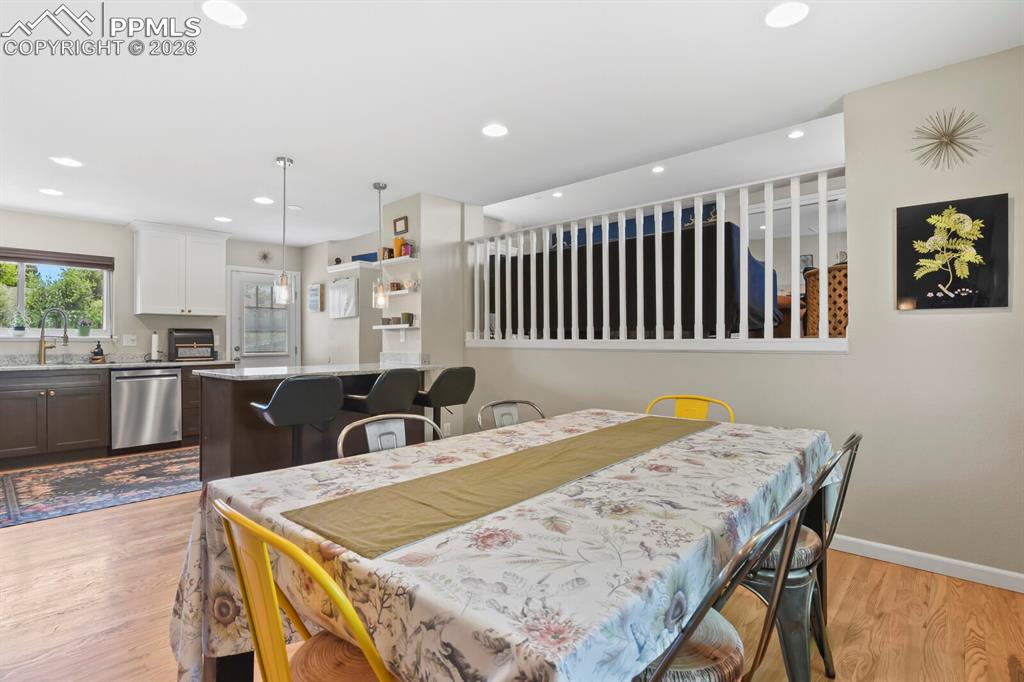 Image 11 of 38: Open concept kitchen and dining area featuring hardwood floors, recessed li