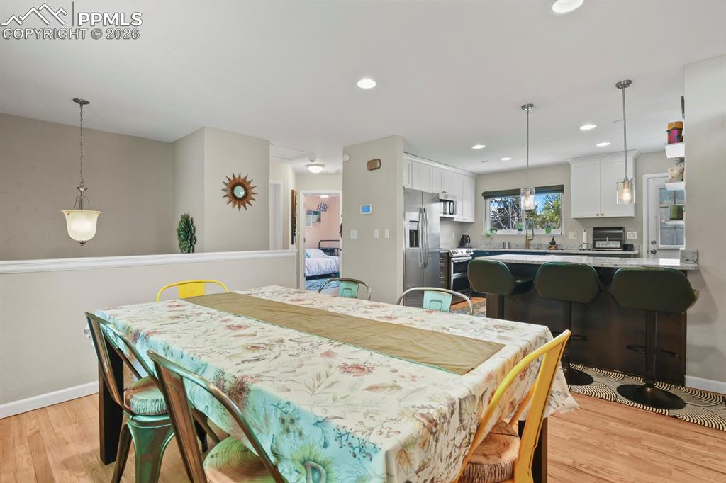 Image 12 of 38: This open-concept area features hardwood floors and recessed lighting throu