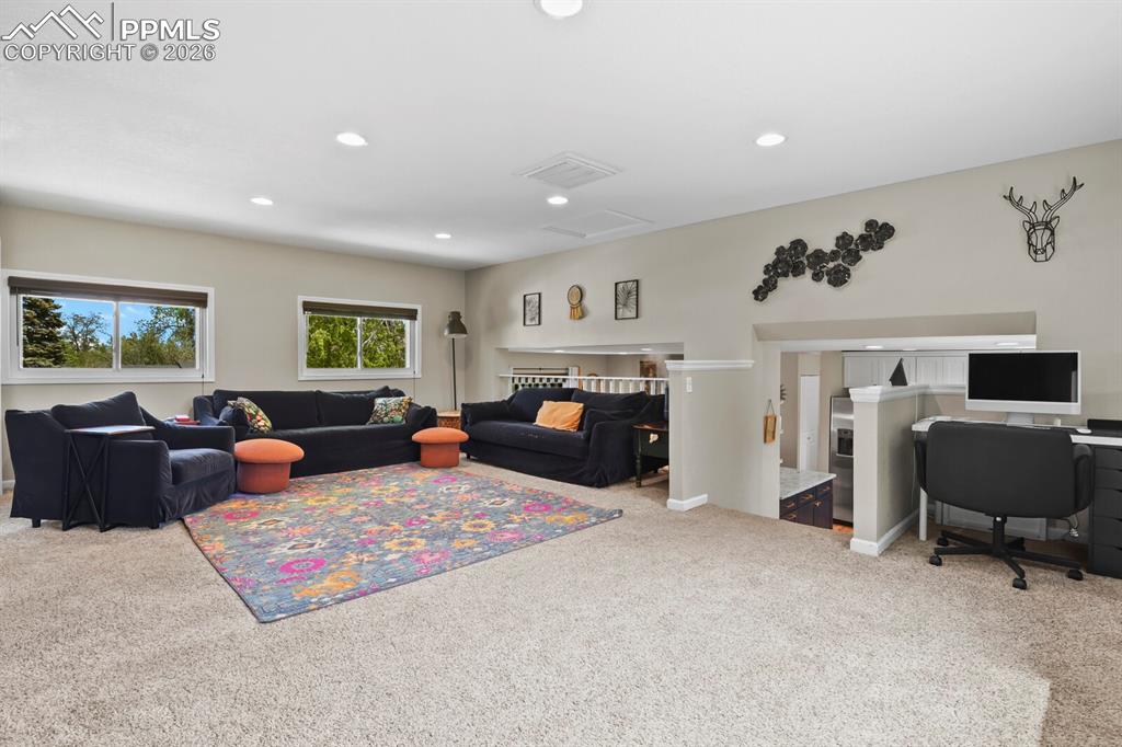 Image 13 of 38: Spacious room featuring carpeting, recessed lighting, and windows providing