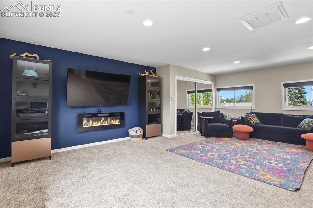 Image 14 of 38: Living area featuring carpet flooring, recessed lighting, and a modern wall