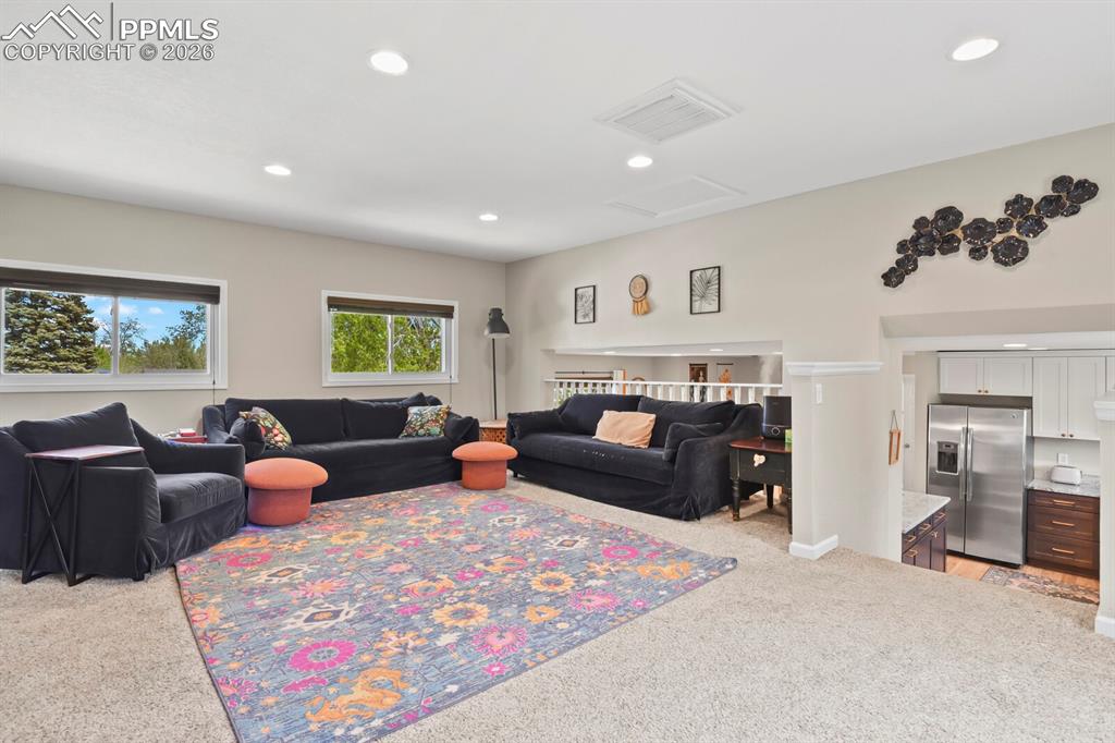 Image 15 of 38: The property features an expansive living area with recessed lighting, carp