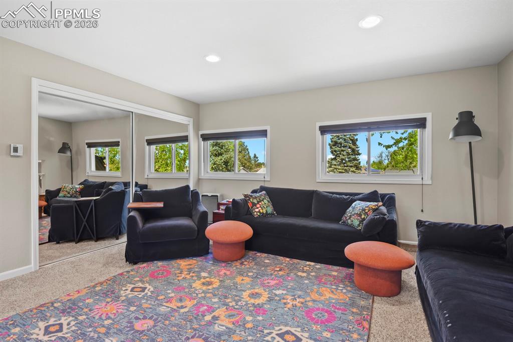 Image 16 of 38: This inviting room features neutral-toned walls, recessed lighting, and win