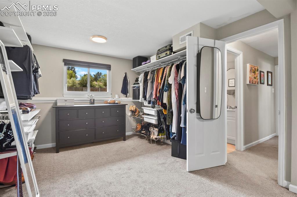 Image 27 of 38: This room features carpeted flooring, a window with a blind, and overhead l