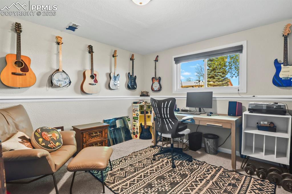 Image 29 of 38: This bedroom features carpeted flooring and a window providing natural ligh