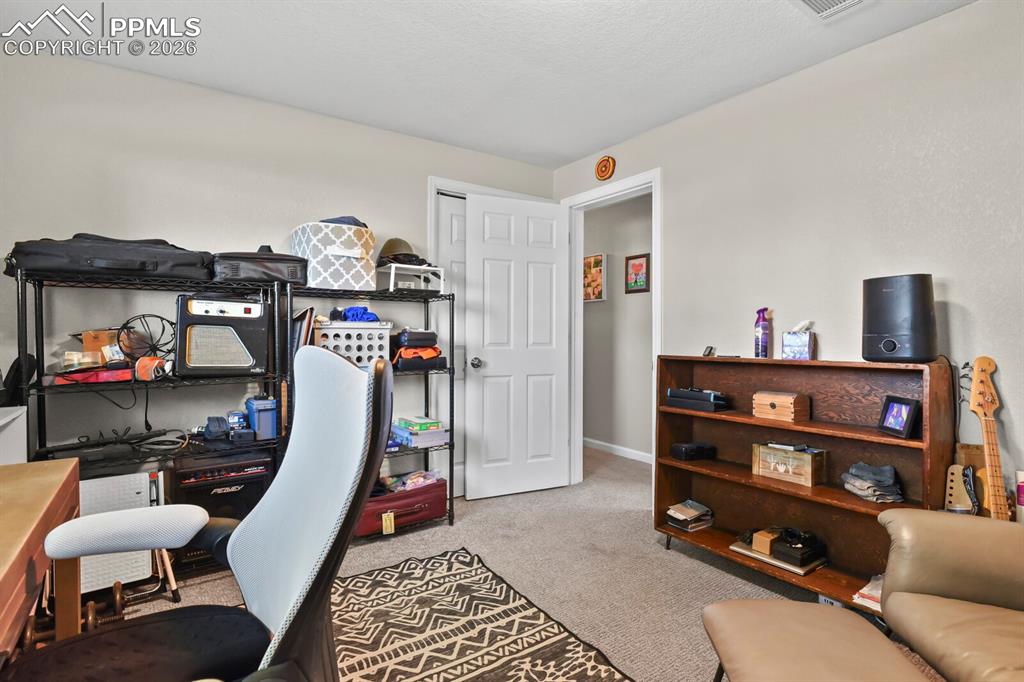 Image 30 of 38: This bedroom features carpeted flooring and a window providing natural ligh