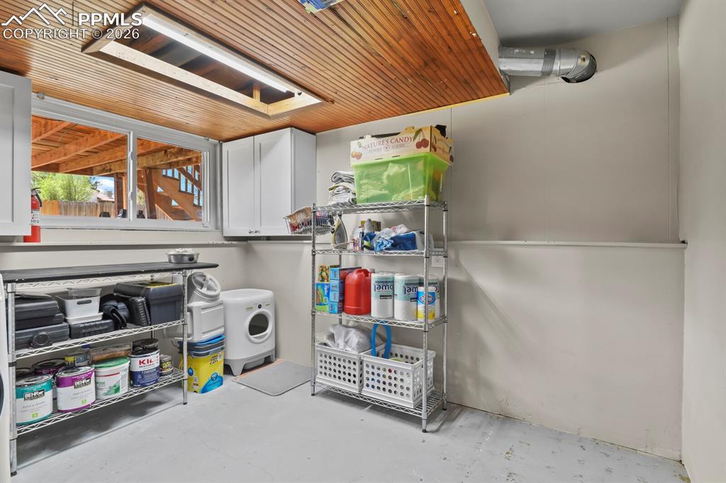 Image 31 of 38: The utility room is paired with the laundry room on the lower level. Featur