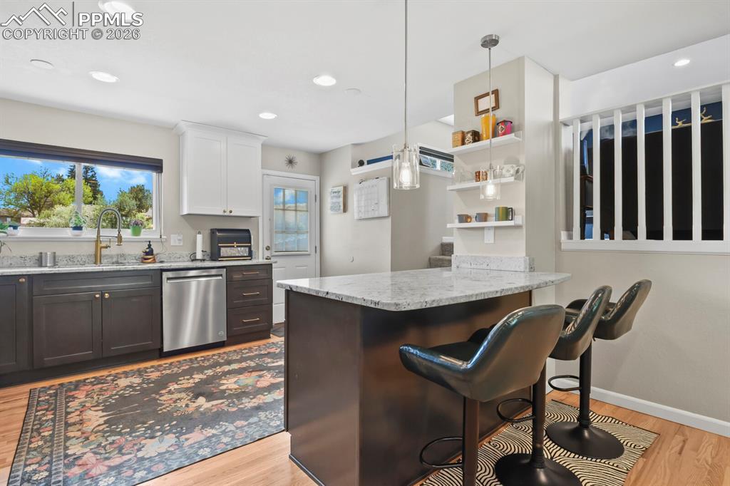 Image 4 of 38: The kitchen features a functional layout with dark lower cabinetry, white u