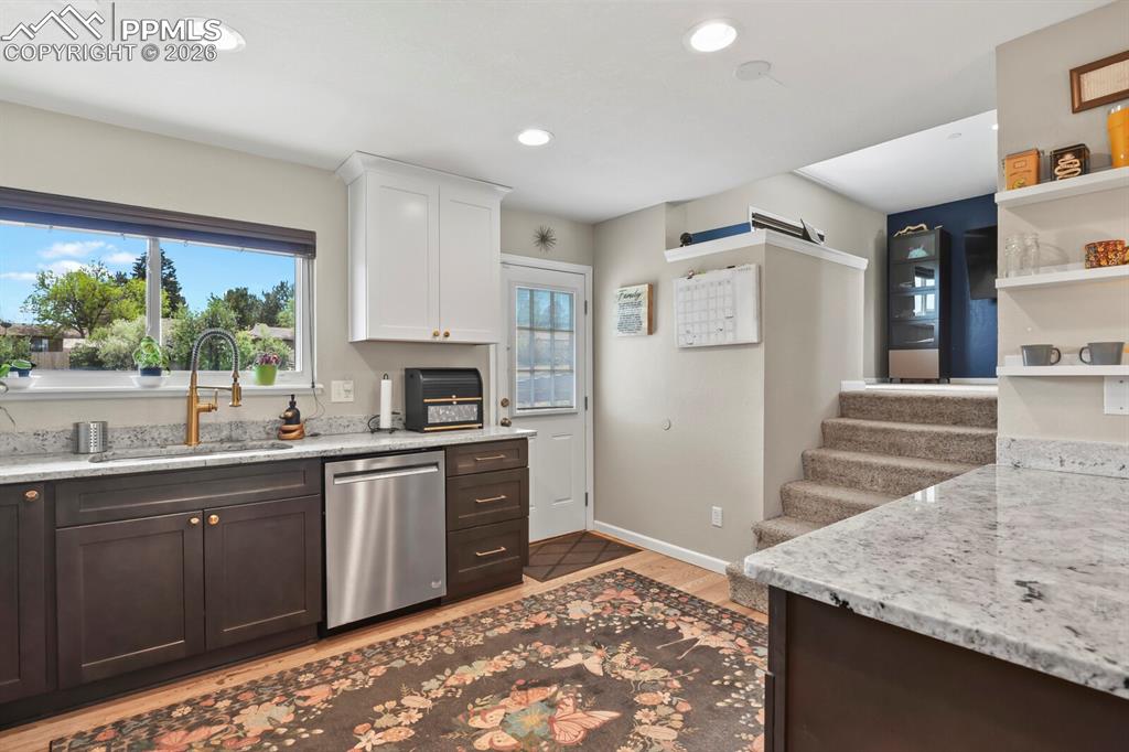 Image 5 of 38: The kitchen features a window overlooking the back, granite countertops, tw