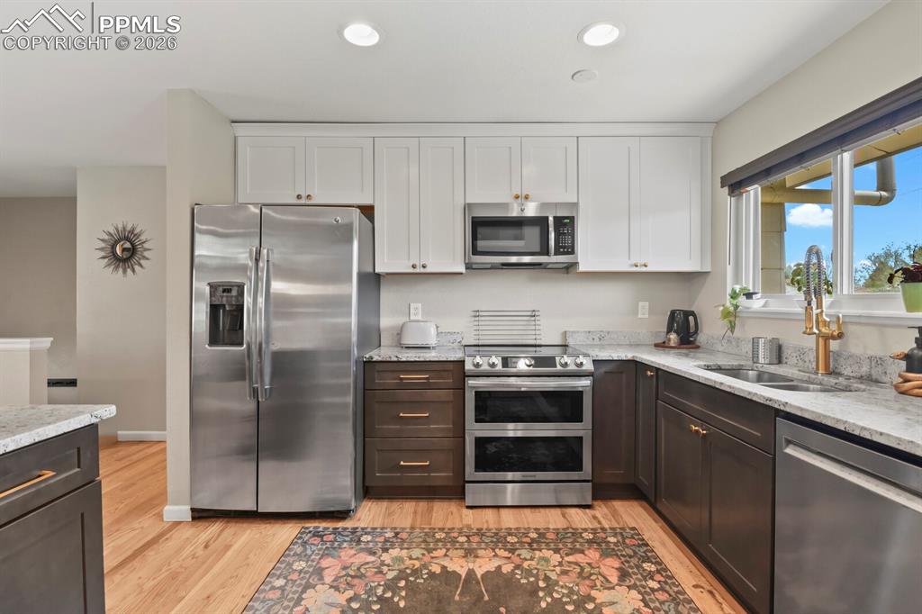 Image 6 of 38: The kitchen features stainless steel appliances, including a side-by-side r