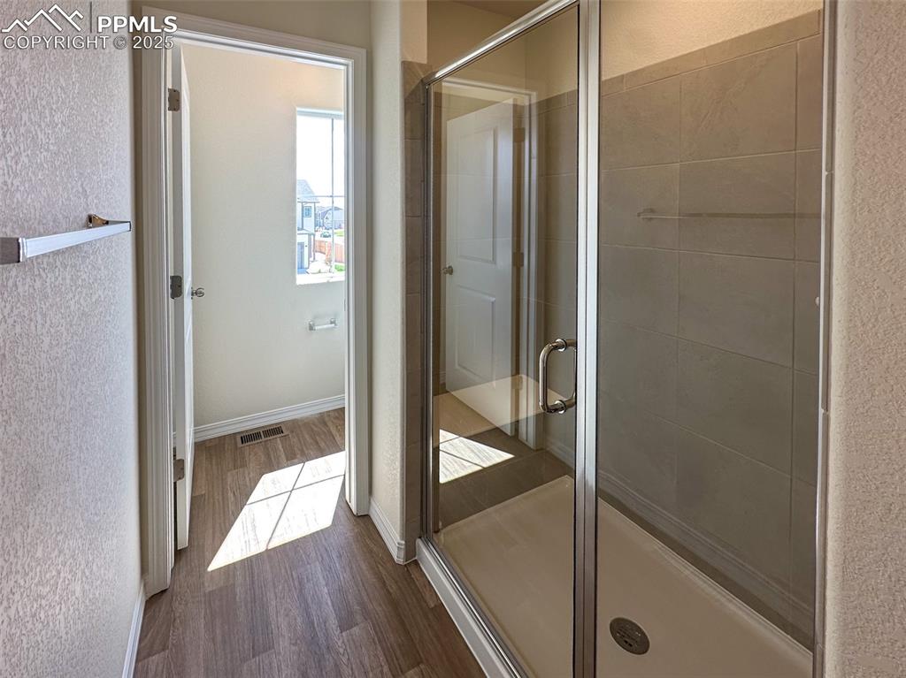 Image 33 of 35: Walk in shower with seat and ceramic tile 