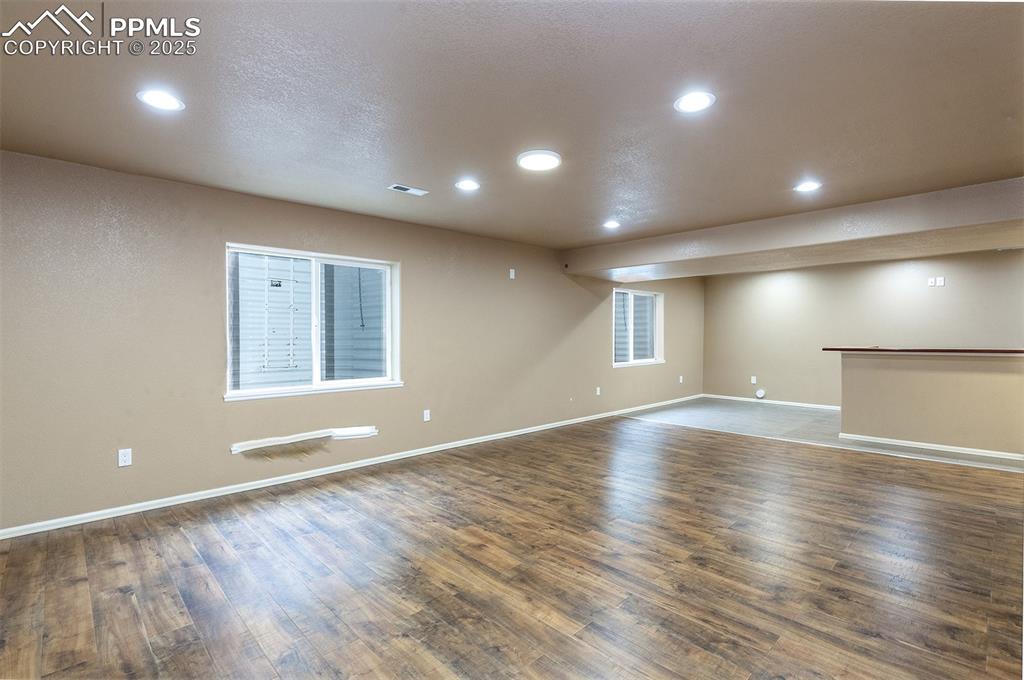Image 12 of 46: Finished basement featuring recessed lighting and wood finished floors