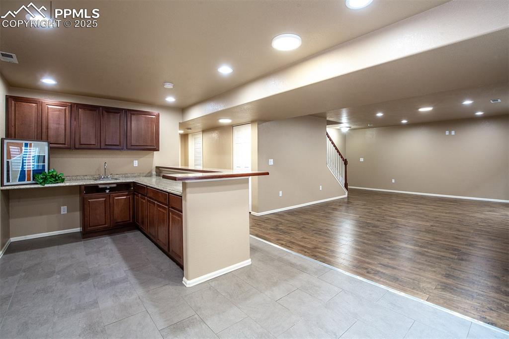 Image 15 of 46: Kitchen with a peninsula, open floor plan, recessed lighting, wood finished
