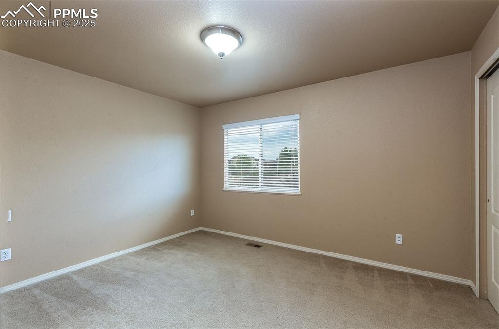 Image 23 of 46: Carpeted spare room featuring baseboards