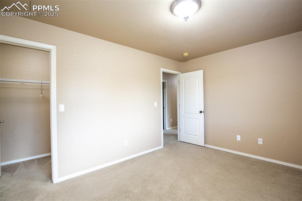 Image 25 of 46: Unfurnished bedroom with light carpet and a spacious closet