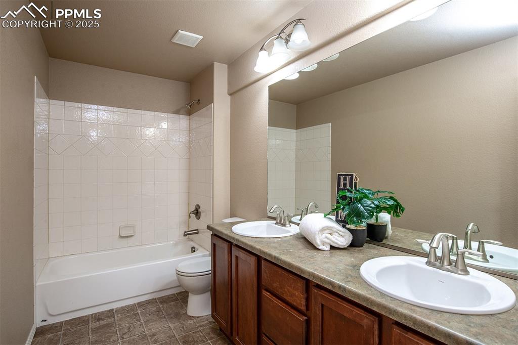 Image 27 of 46: Full bathroom featuring double vanity and washtub / shower combination