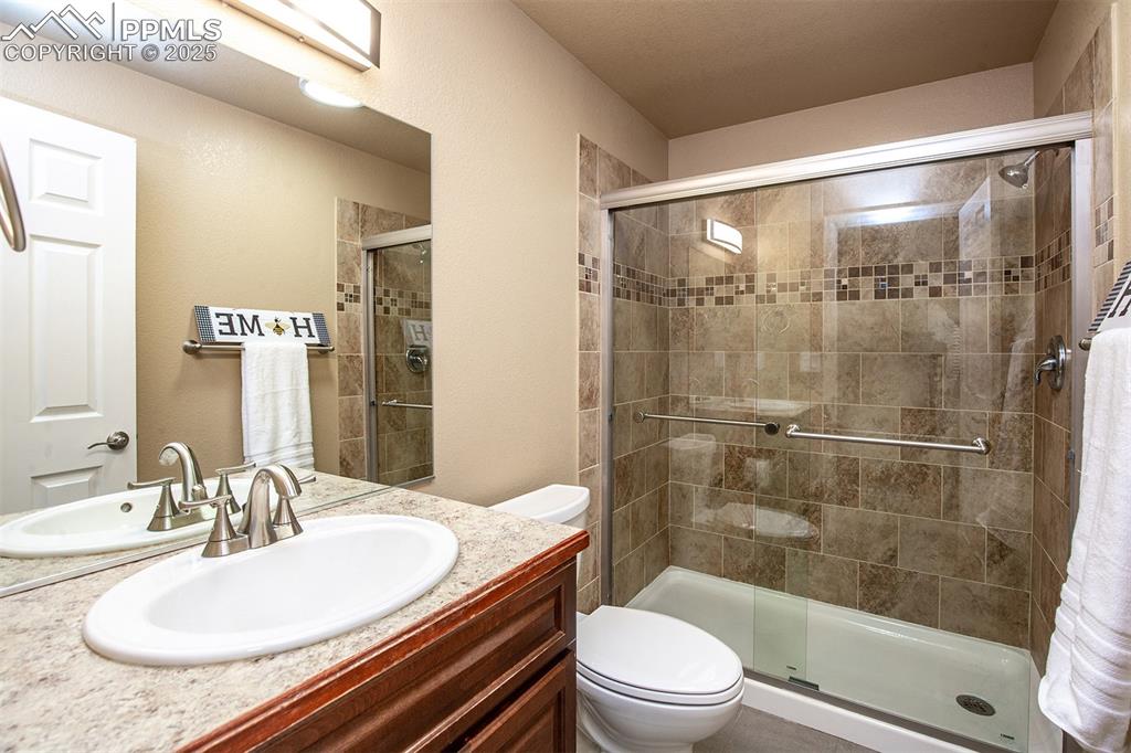 Image 30 of 46: Bathroom with a stall shower and vanity
