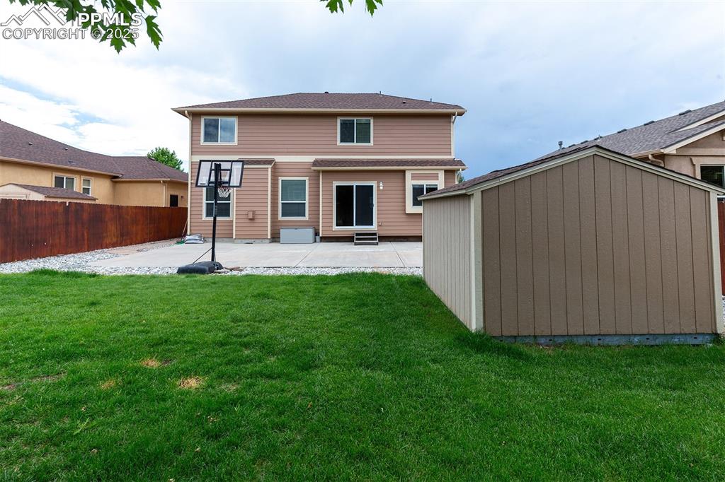 Image 34 of 46: Rear view of house featuring a patio area and a storage shed