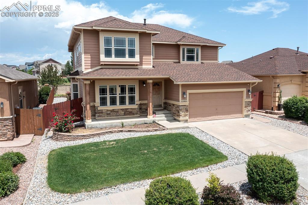Image 45 of 46: View of front of property featuring a garage, driveway, a shingled roof, an