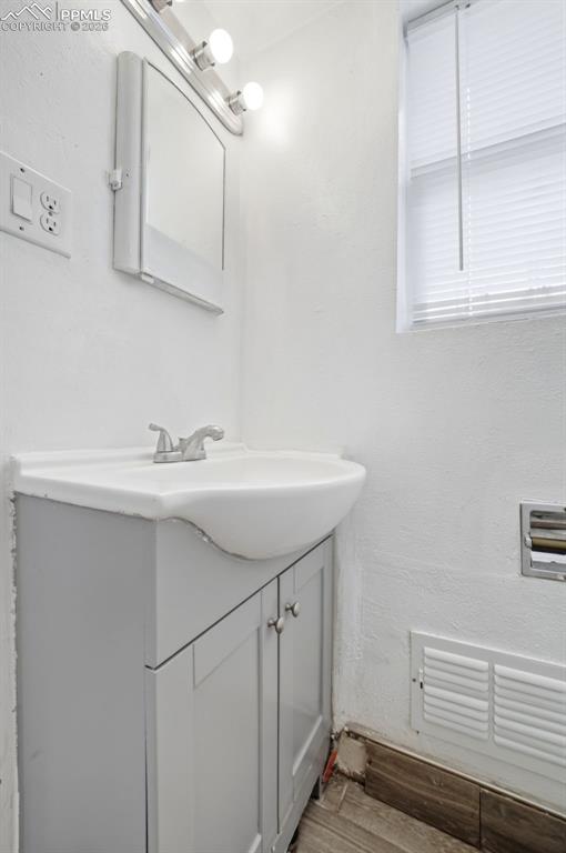 Image 12 of 50: Vanity with integrated sink, chrome faucet, and grey cabinetry, complemente