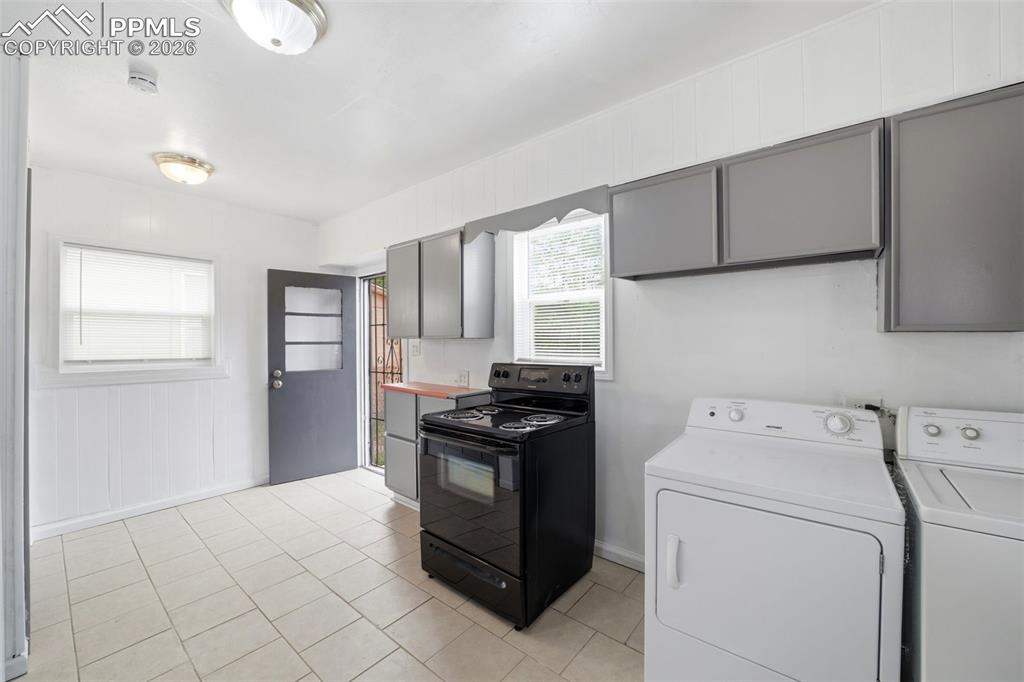 Image 18 of 50: Kitchen space featuring tile flooring, white wainscoting, an exterior door 