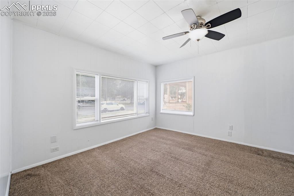 Image 22 of 50: Spacious room featuring neutral carpet, white walls, multiple windows with 