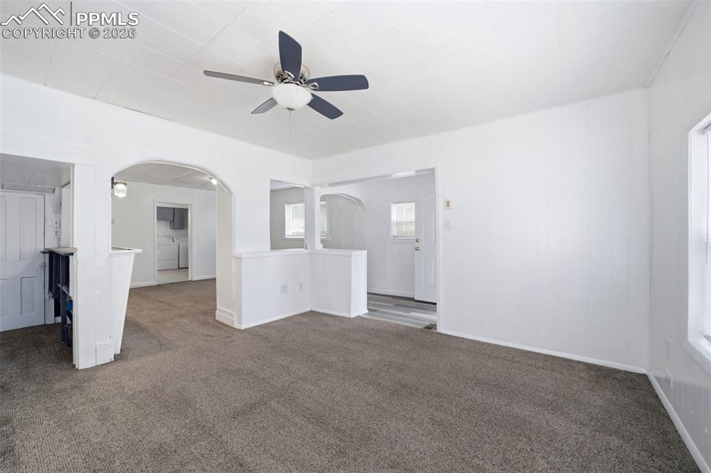 Image 24 of 50: Living area featuring neutral carpeting, white walls, and a ceiling fan wit