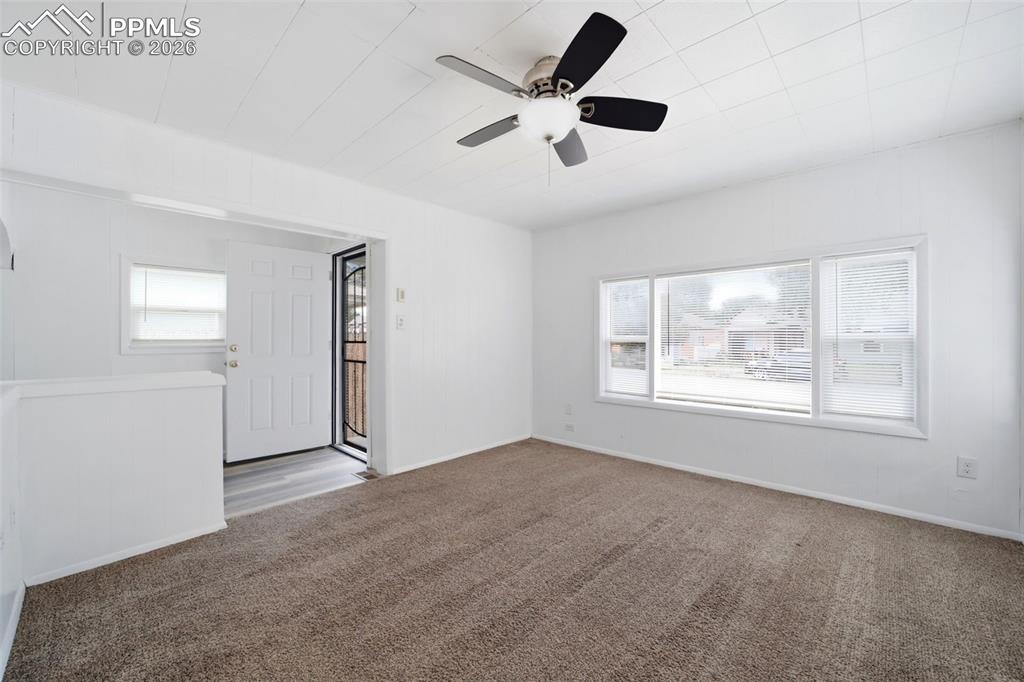 Image 25 of 50: Spacious room featuring a multi-pane window, neutral carpet flooring, a cei